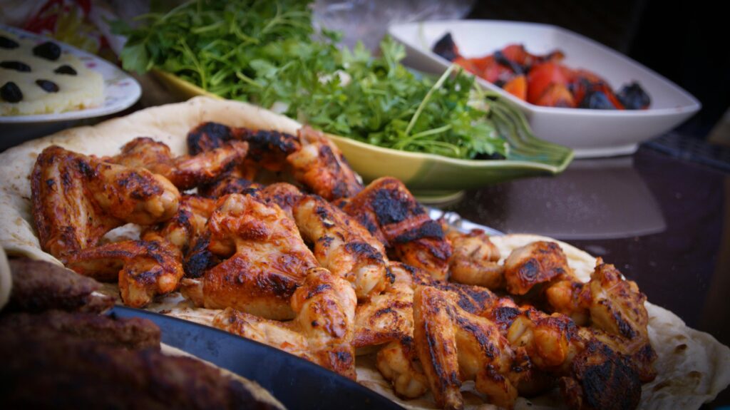 pexels-photo-106343-106343 A close-up of grilled chicken wings served with fresh herbs and vegetables, perfect for culinary presentations.