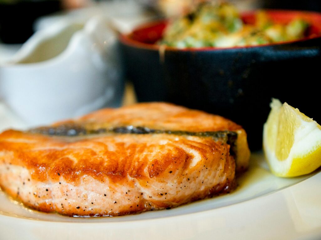 pexels-photo-2374946-2374946 Delicious pan-seared salmon steak garnished with a lemon slice, showcasing a perfect dining experience.