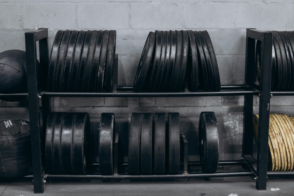 Rows of weight plates on a rack in a gym setting, creating a focused and organized fitness space.